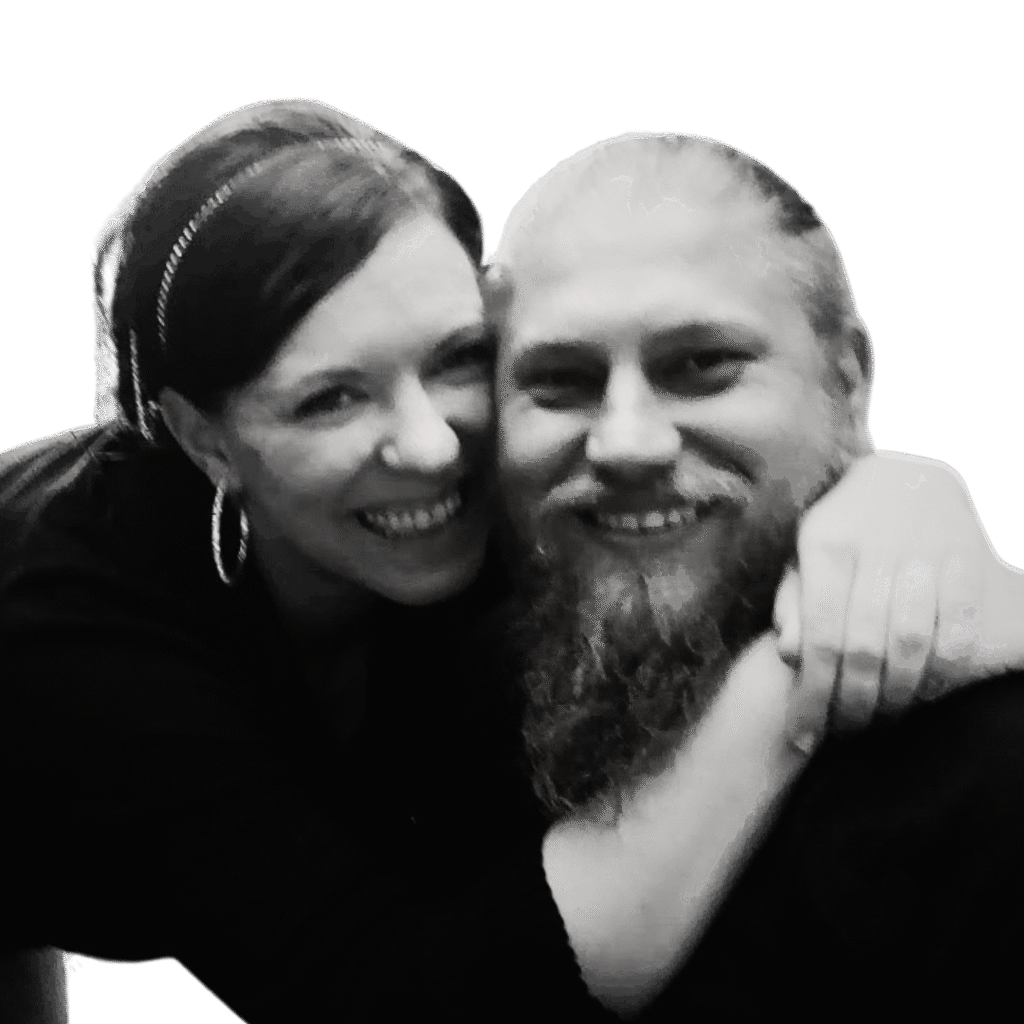 A black and white portrait of authors Jared and Danielle Lemky. Danielle is smiling and hugging Jared from behind, representing their co-author partnership for JD Lemky.