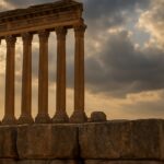 The towering Roman columns of the Temple of Jupiter at Baalbek, Lebanon, silhouetted against the setting sun.
